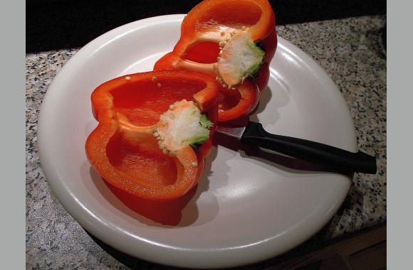Halbieren Sie die Paprika und entkernen Sie sie.